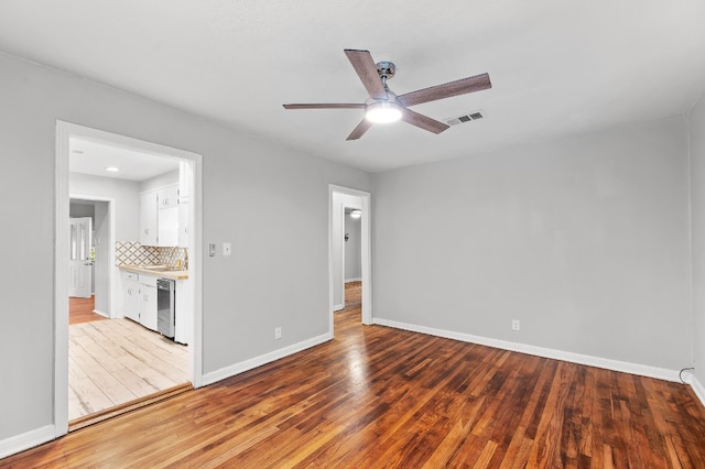 empty room with ceiling fan and light hardwood / wood-style floors