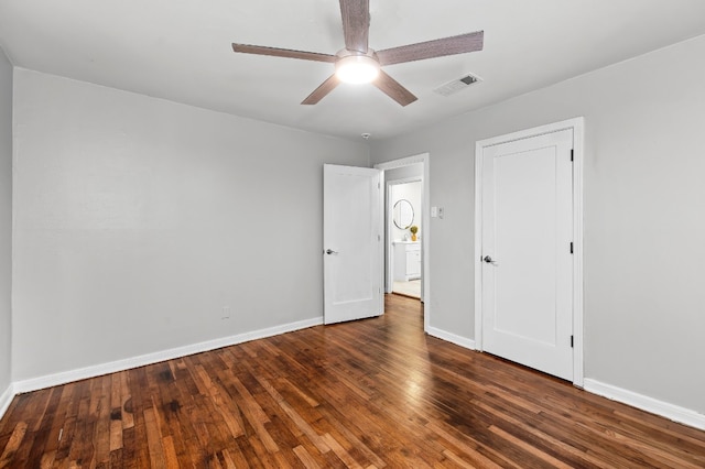 unfurnished room with ceiling fan and dark wood-type flooring