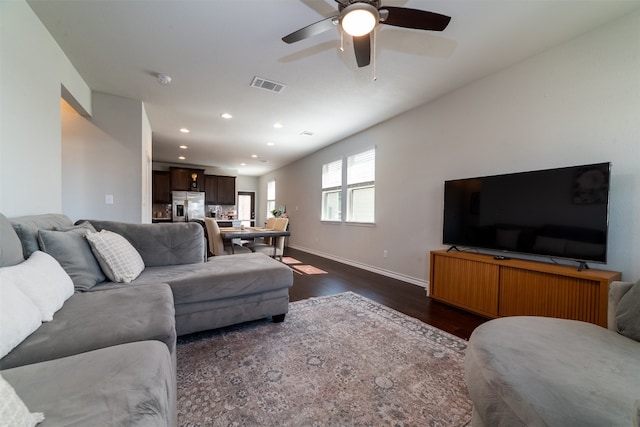 living room featuring ceiling fan and dark hardwood / wood-style floors