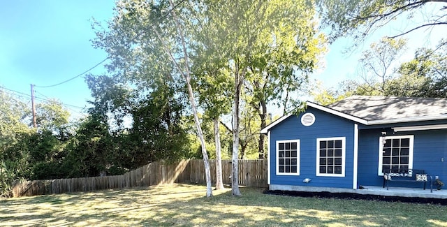 view of side of home with a yard