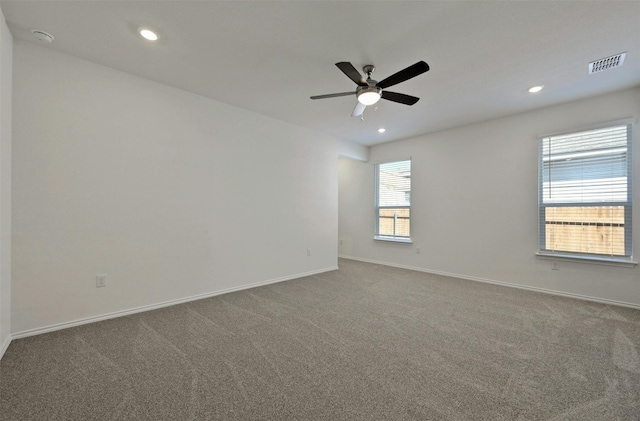 spare room with ceiling fan and carpet