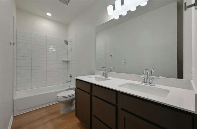 full bathroom featuring tiled shower / bath, vanity, toilet, and wood-type flooring