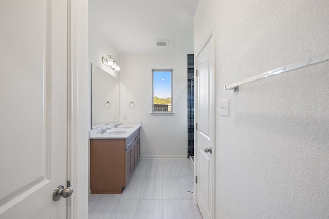 bathroom featuring a shower, vanity, and tile patterned floors