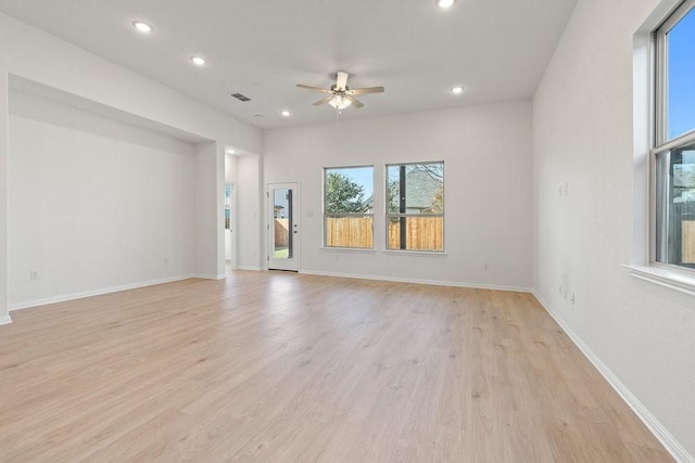 empty room with ceiling fan and light hardwood / wood-style flooring