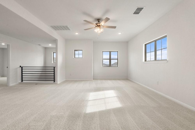 spare room with ceiling fan and light colored carpet