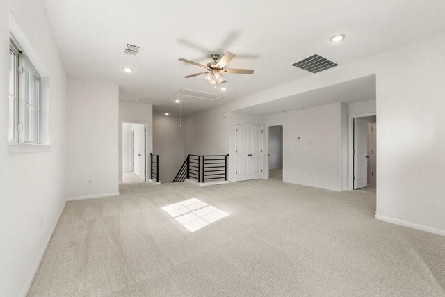 carpeted spare room featuring ceiling fan