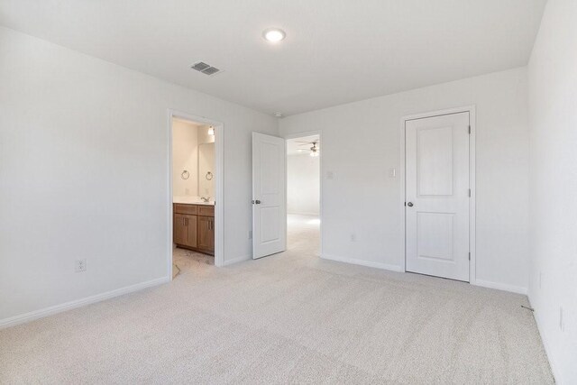 unfurnished bedroom with light carpet and ensuite bath