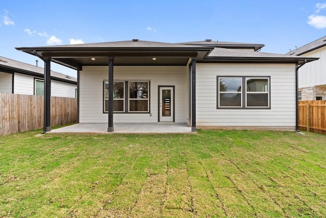 back of property with a patio and a lawn