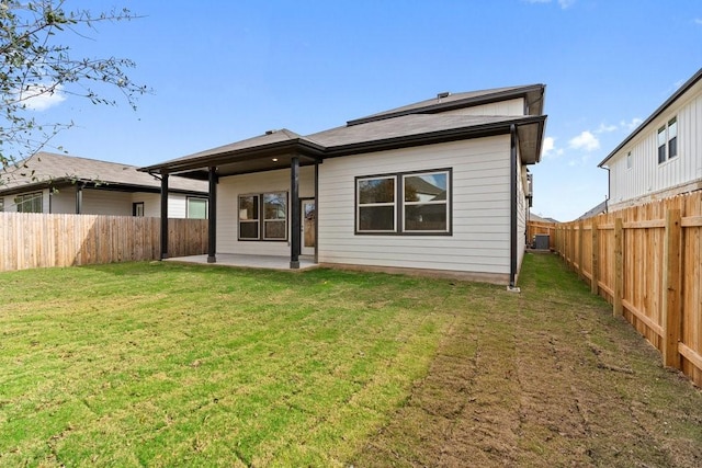 rear view of property featuring cooling unit, a patio area, and a yard