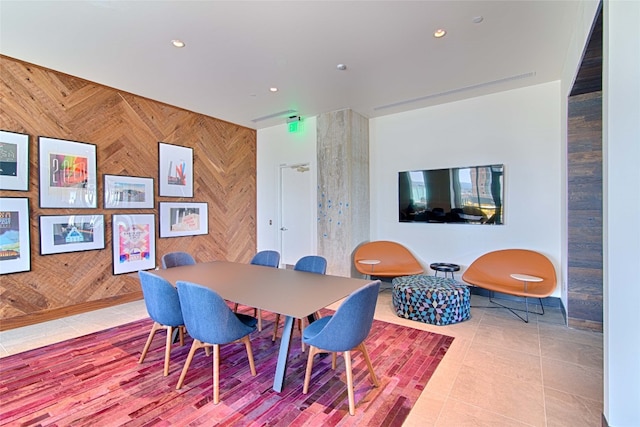 tiled dining area featuring wood walls