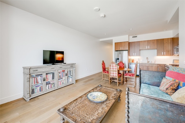 living room featuring light hardwood / wood-style flooring and sink