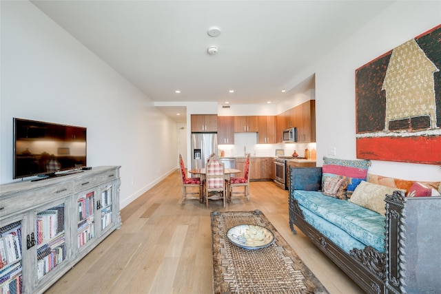 living room featuring light wood-type flooring and sink