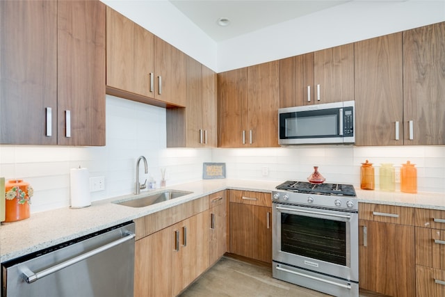 kitchen featuring light stone countertops, sink, stainless steel appliances, and tasteful backsplash