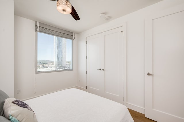 bedroom with a closet, wood-type flooring, and ceiling fan