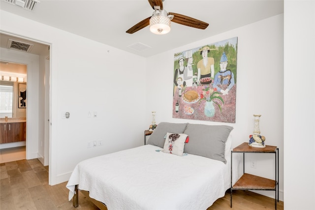 bedroom with connected bathroom, ceiling fan, and light hardwood / wood-style flooring