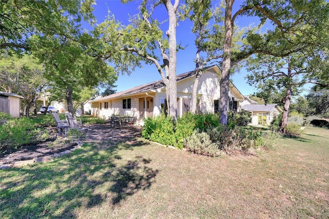 exterior space featuring a front lawn and a patio area