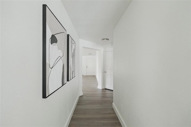 corridor with dark hardwood / wood-style flooring