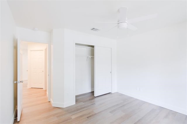 unfurnished bedroom featuring light hardwood / wood-style floors, ceiling fan, and a closet