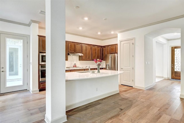 kitchen with sink, light hardwood / wood-style flooring, appliances with stainless steel finishes, backsplash, and ornamental molding