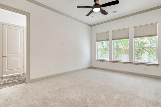 unfurnished room with light carpet, visible vents, baseboards, a ceiling fan, and crown molding