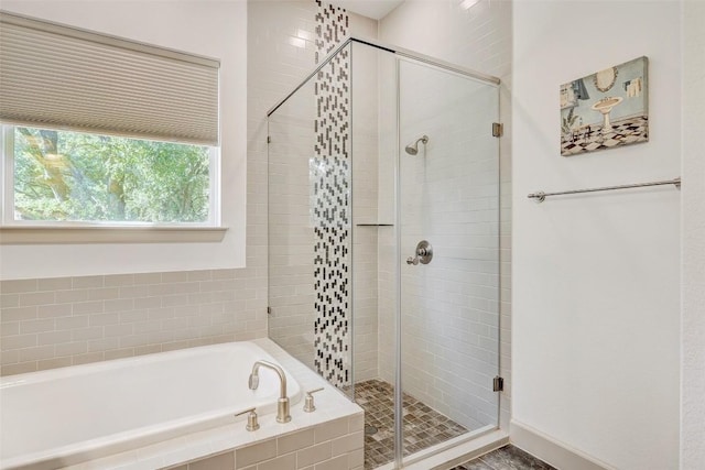 bathroom featuring a stall shower and a bath