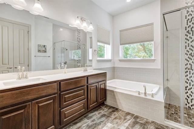 bathroom with double vanity, a sink, a shower stall, and a bath