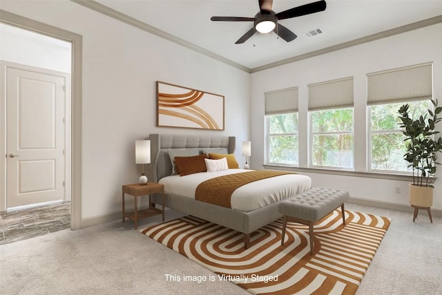 carpeted bedroom with visible vents, ornamental molding, ceiling fan, and baseboards