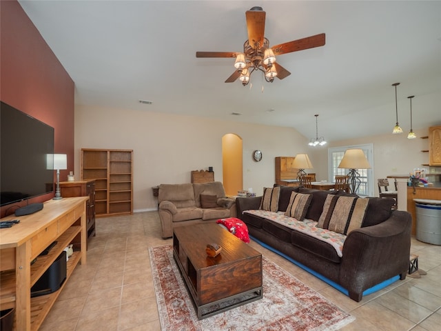 tiled living room with ceiling fan with notable chandelier