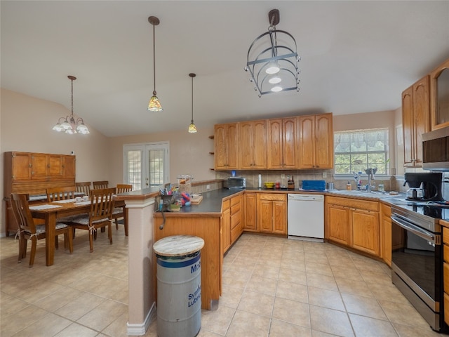 kitchen with stainless steel appliances, sink, a notable chandelier, decorative light fixtures, and light tile patterned floors