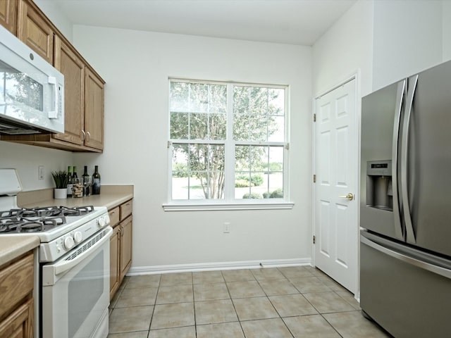 kitchen with white appliances and light tile patterned floors