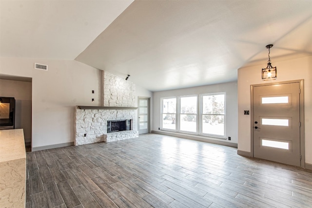 unfurnished living room featuring lofted ceiling, a fireplace, and hardwood / wood-style flooring