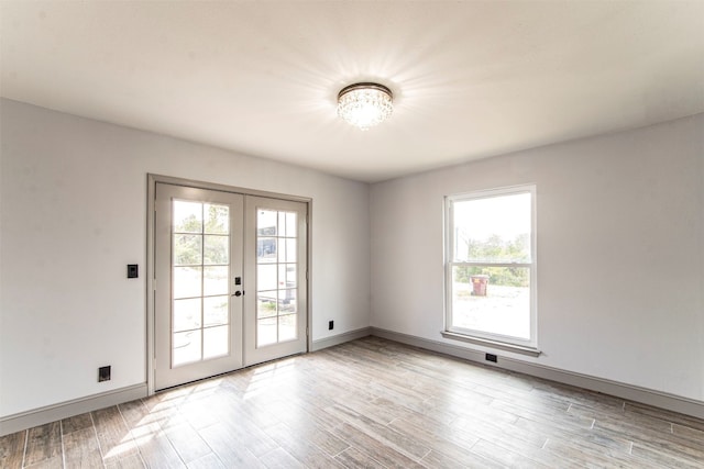 spare room featuring french doors and light wood-type flooring