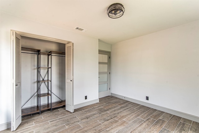 unfurnished bedroom featuring wood-type flooring and a closet