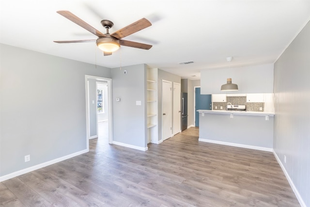 unfurnished living room featuring light wood-type flooring and ceiling fan