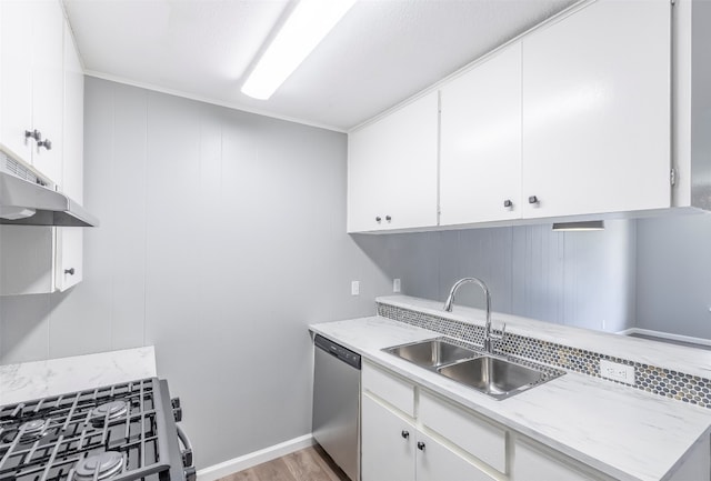 kitchen with appliances with stainless steel finishes, light wood-type flooring, white cabinetry, and sink