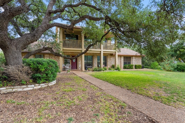 view of front of home with a front yard and a balcony