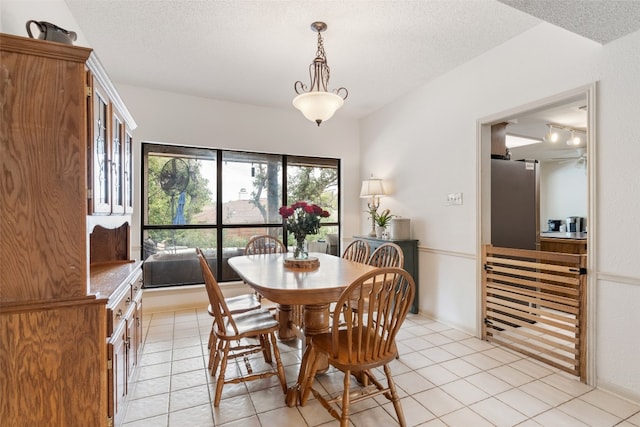 tiled dining room featuring a textured ceiling