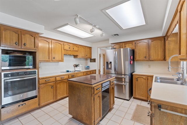 kitchen featuring sink, stainless steel appliances, a center island, and light tile patterned flooring