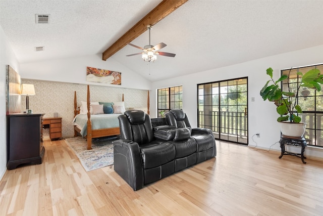 bedroom featuring access to exterior, lofted ceiling with beams, a textured ceiling, light hardwood / wood-style floors, and ceiling fan