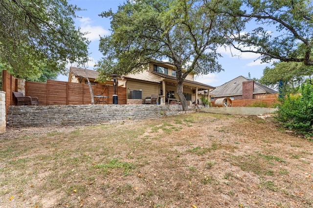 rear view of house featuring a yard