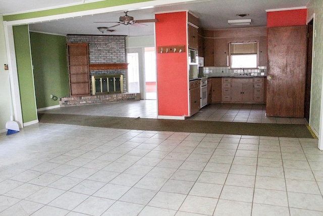 421 Fm 845, Cameron, TX 76520 - kitchen featuring a ceiling fan, a sink, light tile patterned floors, backsplash, and a brick fireplace