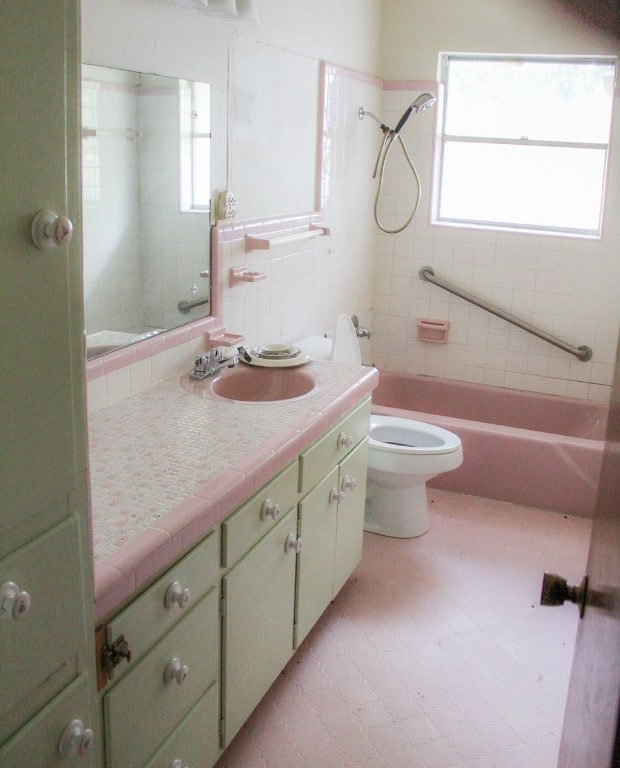 full bathroom featuring a healthy amount of sunlight, tiled shower / bath combo, vanity, and toilet