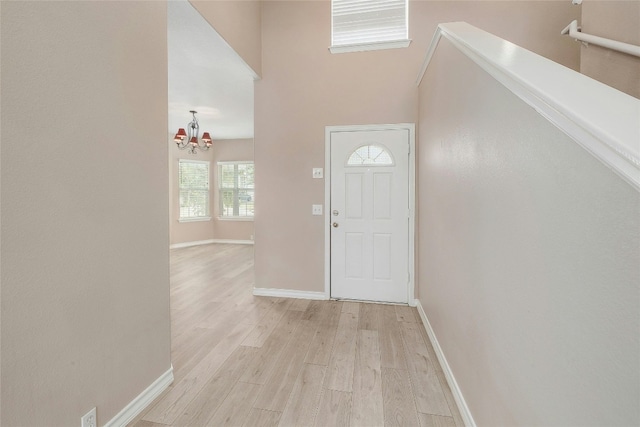 entrance foyer with a notable chandelier and light hardwood / wood-style flooring