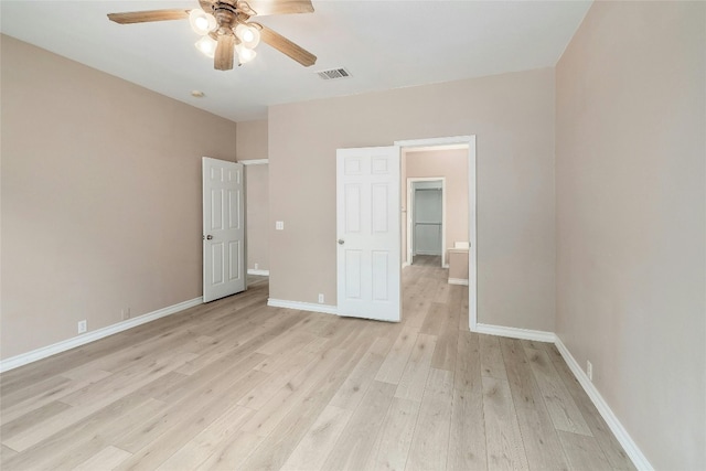 unfurnished bedroom with a spacious closet, ceiling fan, a closet, and light hardwood / wood-style flooring