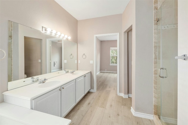 bathroom with wood-type flooring, vanity, and walk in shower