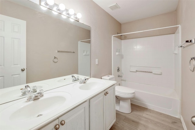 full bathroom with vanity,  shower combination, toilet, and hardwood / wood-style floors