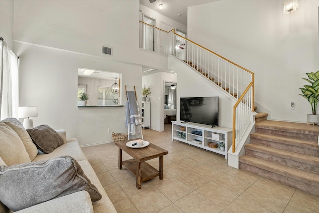 tiled living room featuring a towering ceiling