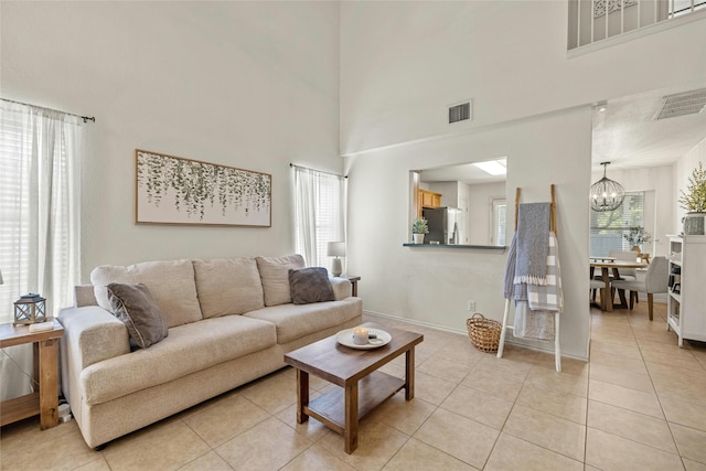 living room featuring an inviting chandelier, a wealth of natural light, and light tile patterned flooring