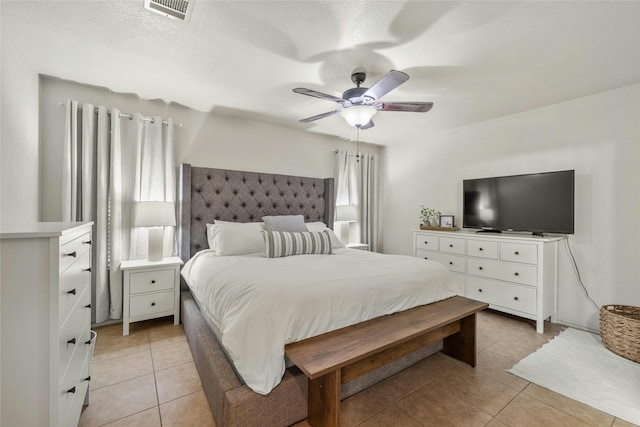 bedroom with light tile patterned floors, a textured ceiling, and ceiling fan