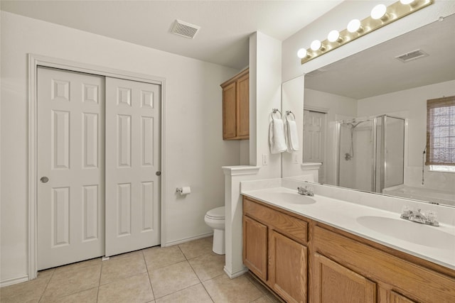 bathroom with tile patterned flooring, vanity, toilet, and an enclosed shower